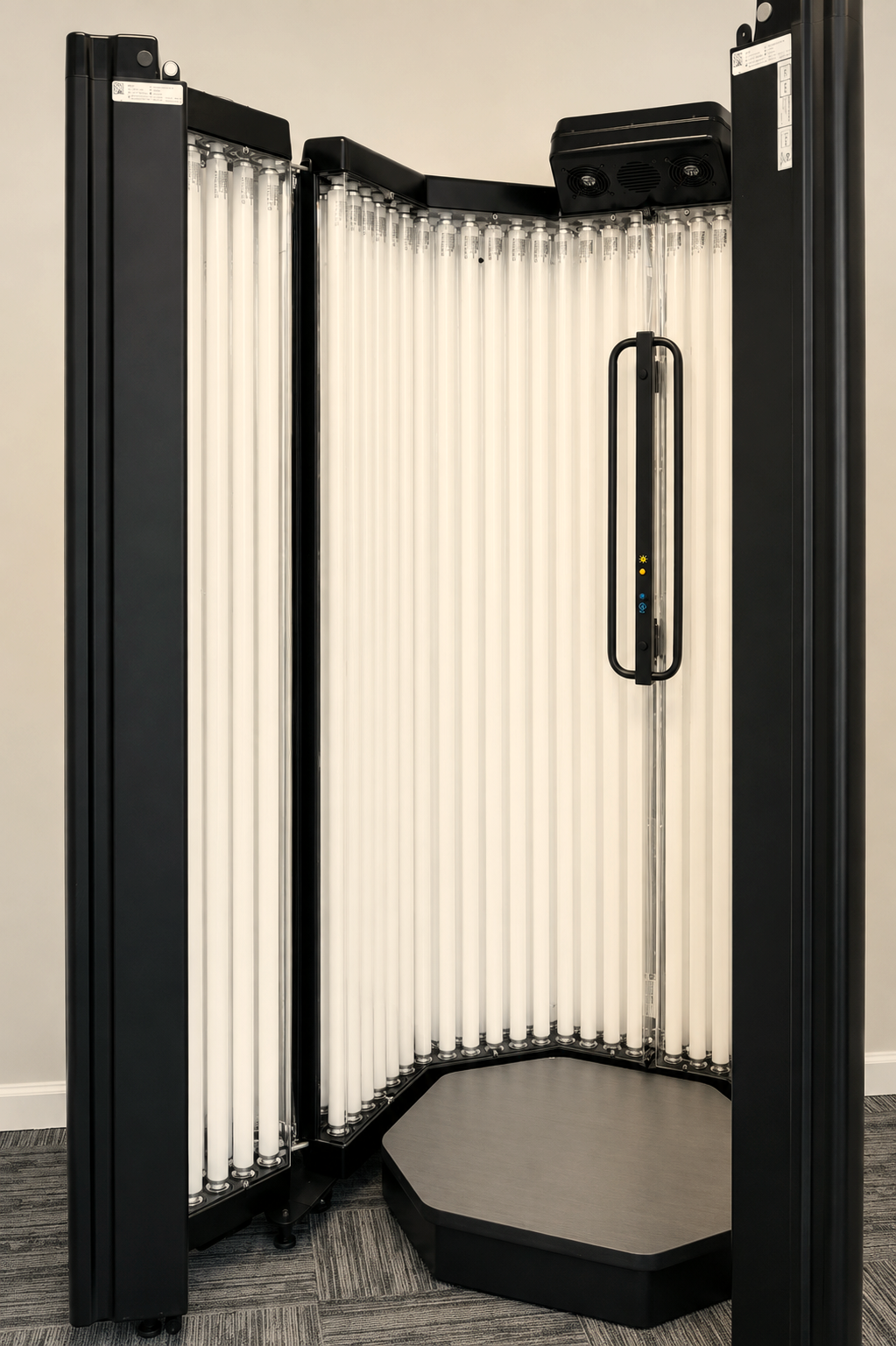 Full-body narrowband UVB phototherapy booth with its doors open in a clinical treatment room